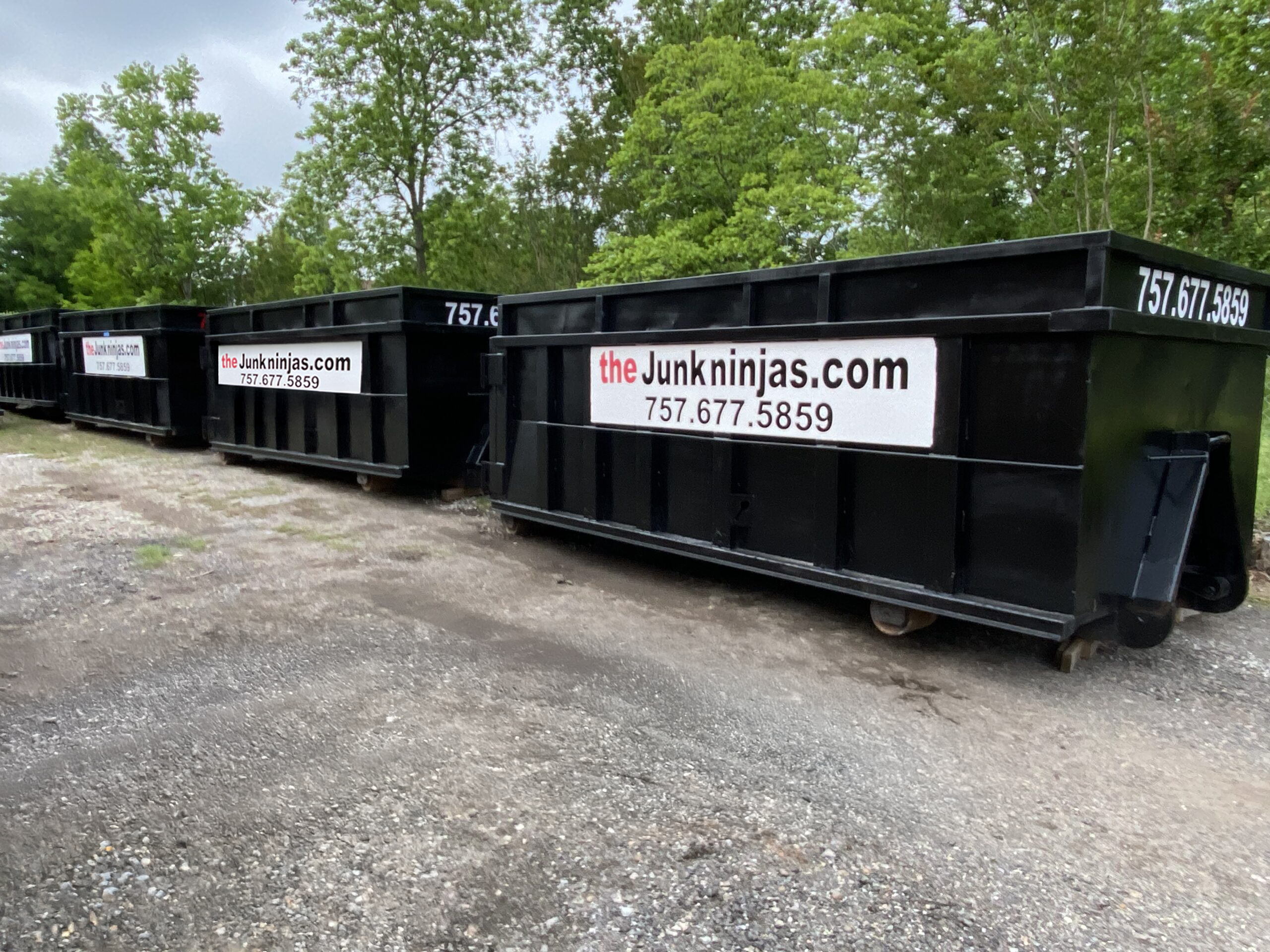 Multiple 20-yard black dumpsters from The Junk Ninjas ready for fast delivery in Virginia Beach and surrounding areas.